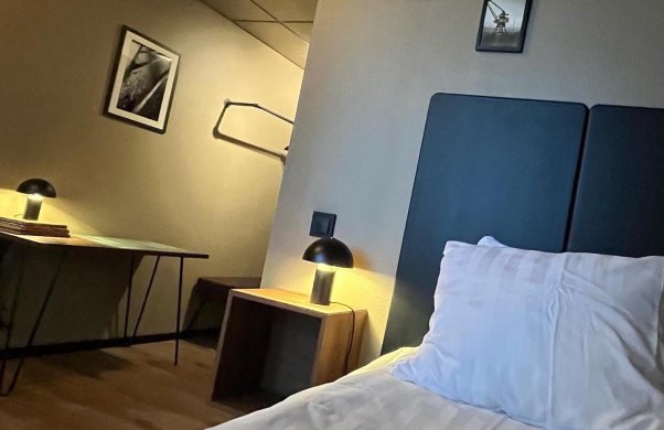 Bild på ett hotellrum. På bilden syns en enkelsäng och ett skrivbord.