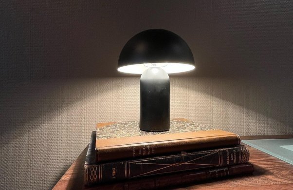 Bild på en skrivbordslampa uppställd på ett bar böcker.