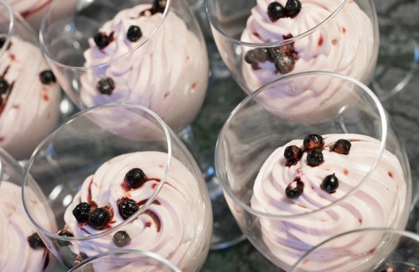 Efterrätt i vinglas, en slags rosa mousse med blåbär på toppen. På bilden syns flera av samma efterrätt ståendes bredvid varandra.